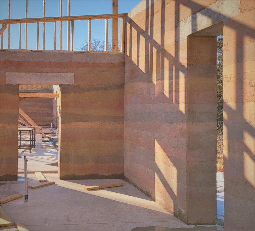 A photo of a house under construction with rammed earth